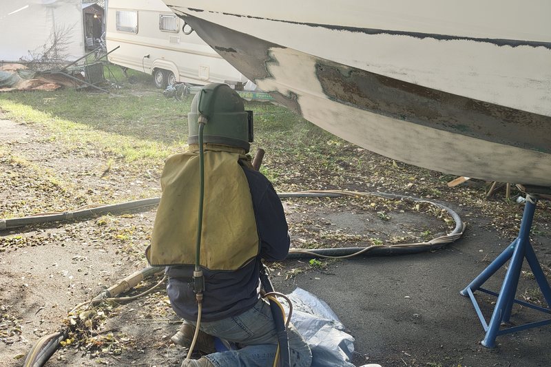 Bootsrumpf aus GFK auf dem Trailer, alte Antifouling-Beschichtung abgetragen